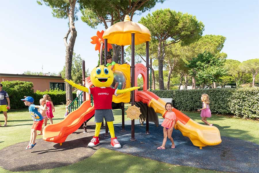 Bambini con la Mascotte che giocano al parco giochi del Pappasole Camping Village