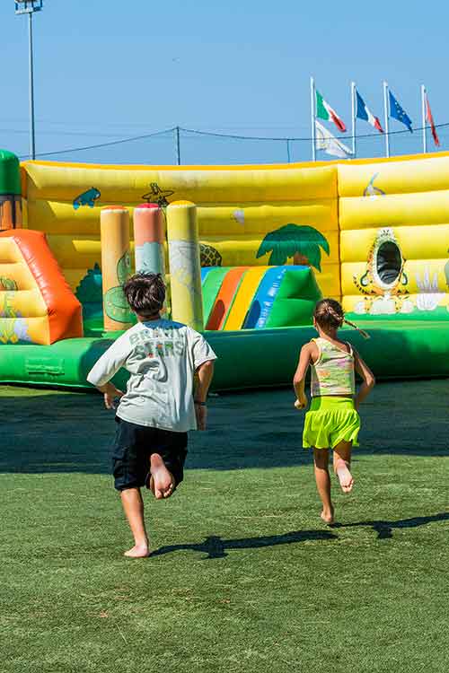 Bambini che giocano ai gonfiabili del Parco Giochi del Pappasole Camping Village