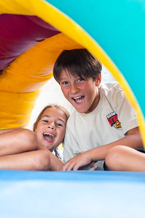 Bambini che giocano ai gonfiabili del Parco Giochi del Pappasole Camping Village