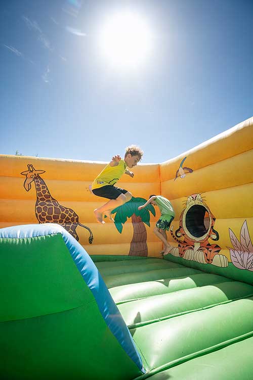 Bambini che giocano ai gonfiabili del Parco Giochi del Pappasole Camping Village