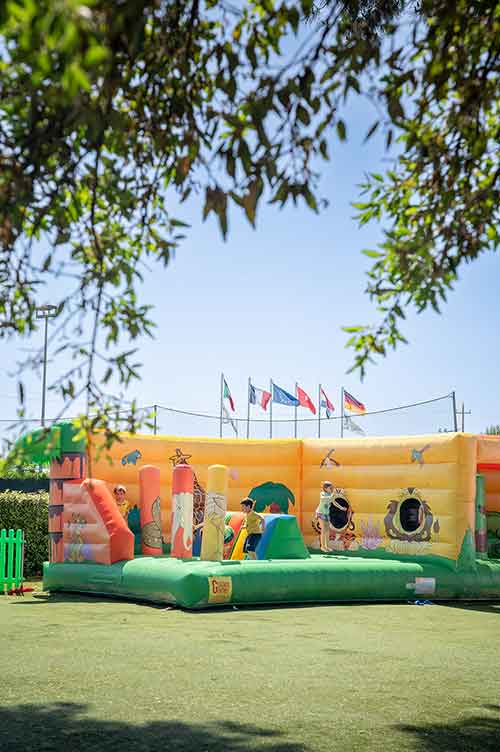 Bambini che giocano ai gonfiabili del Parco Giochi del Pappasole Camping Village